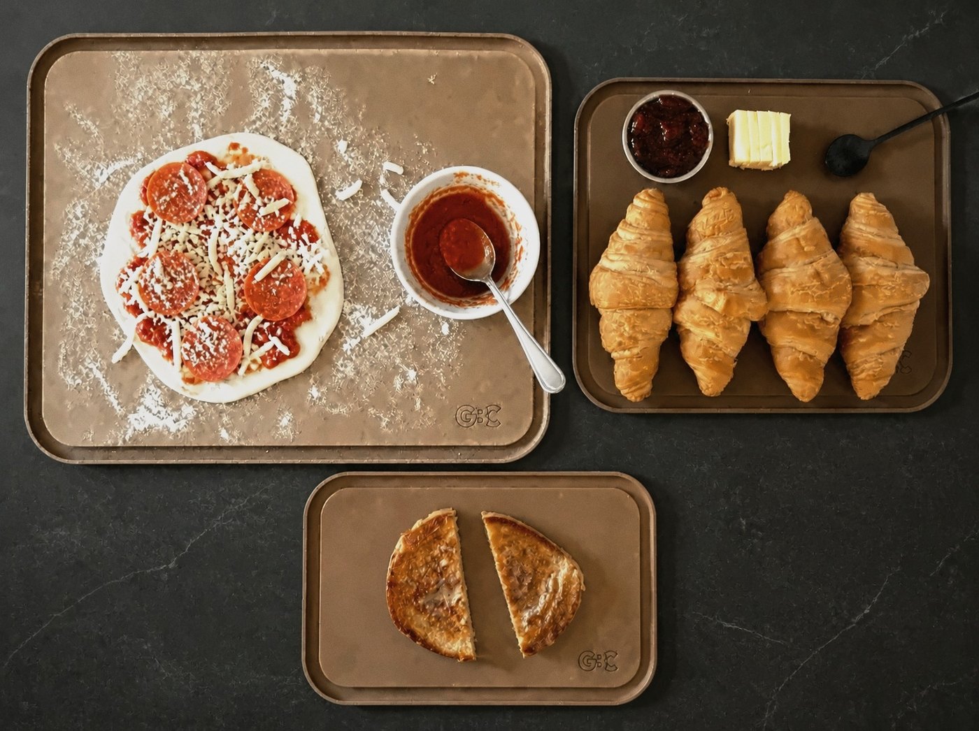 Pizza night on the Richlite Set: pizza on the serving platter, croissants on the R50, grilled cheese on the Mini